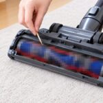 髪の毛やゴミが付着した掃除機のヘッドを掃除している様子